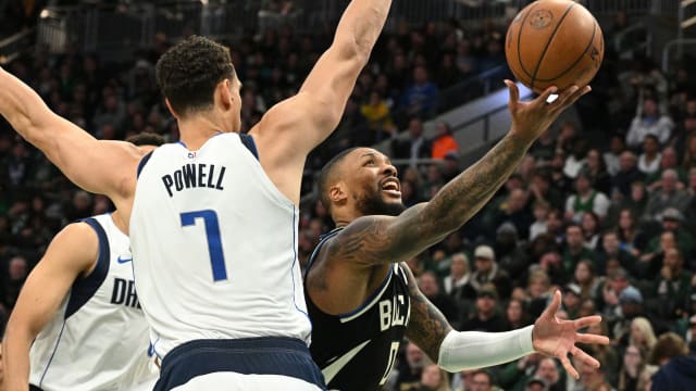 Milwaukee Bucks guard Damian Lillard (0) puts up a shot against Dallas Mavericks center Dwight Powell (7)
